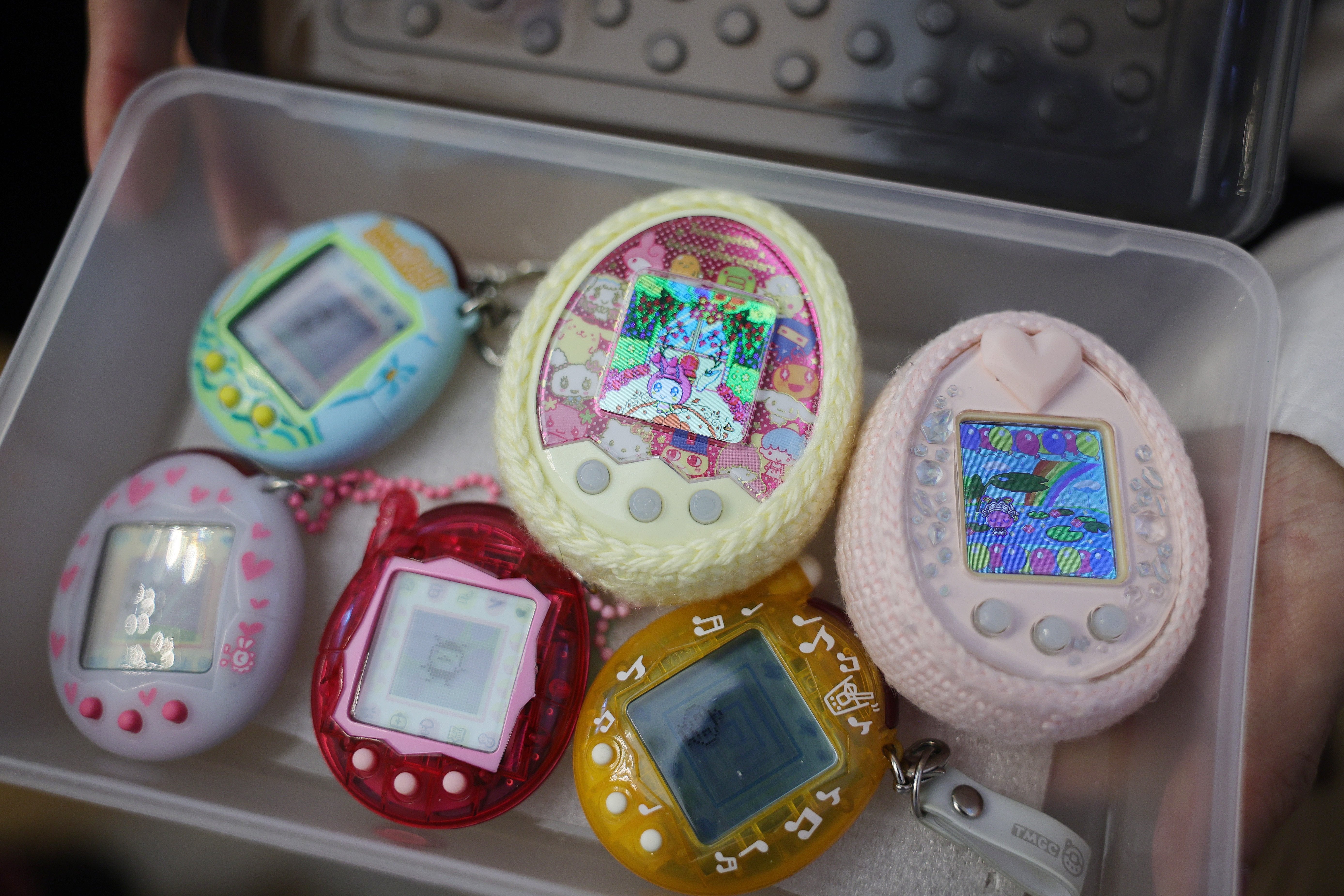 Collection of assorted  Tamagotchi integer  pets successful  a integrative  container, showcasing antithetic  designs and surface  displays