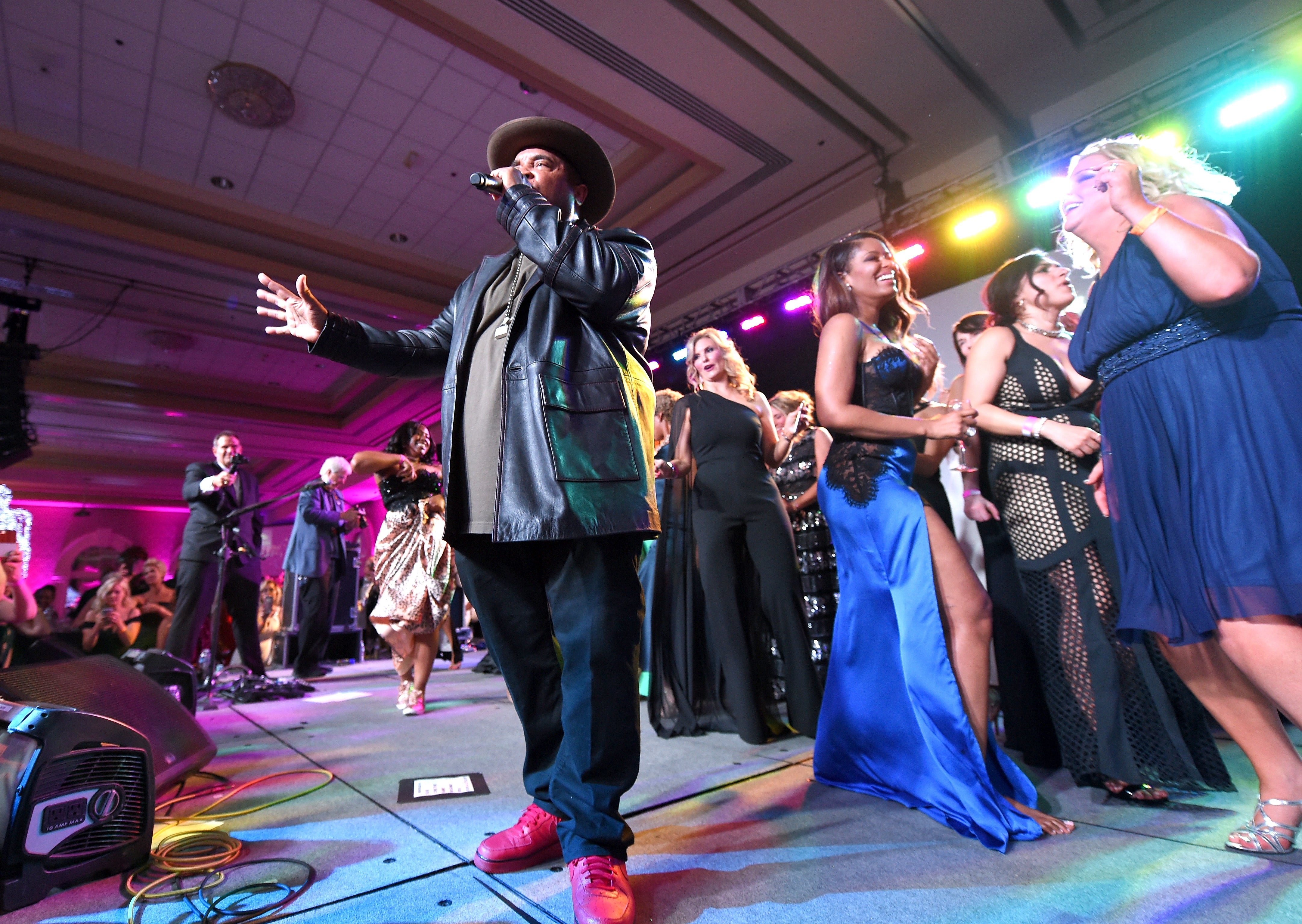 A performer sings connected  signifier    astatine  a lively lawsuit   with an audience, including radical   dressed successful  ceremonial  attire, dancing and enjoying the music