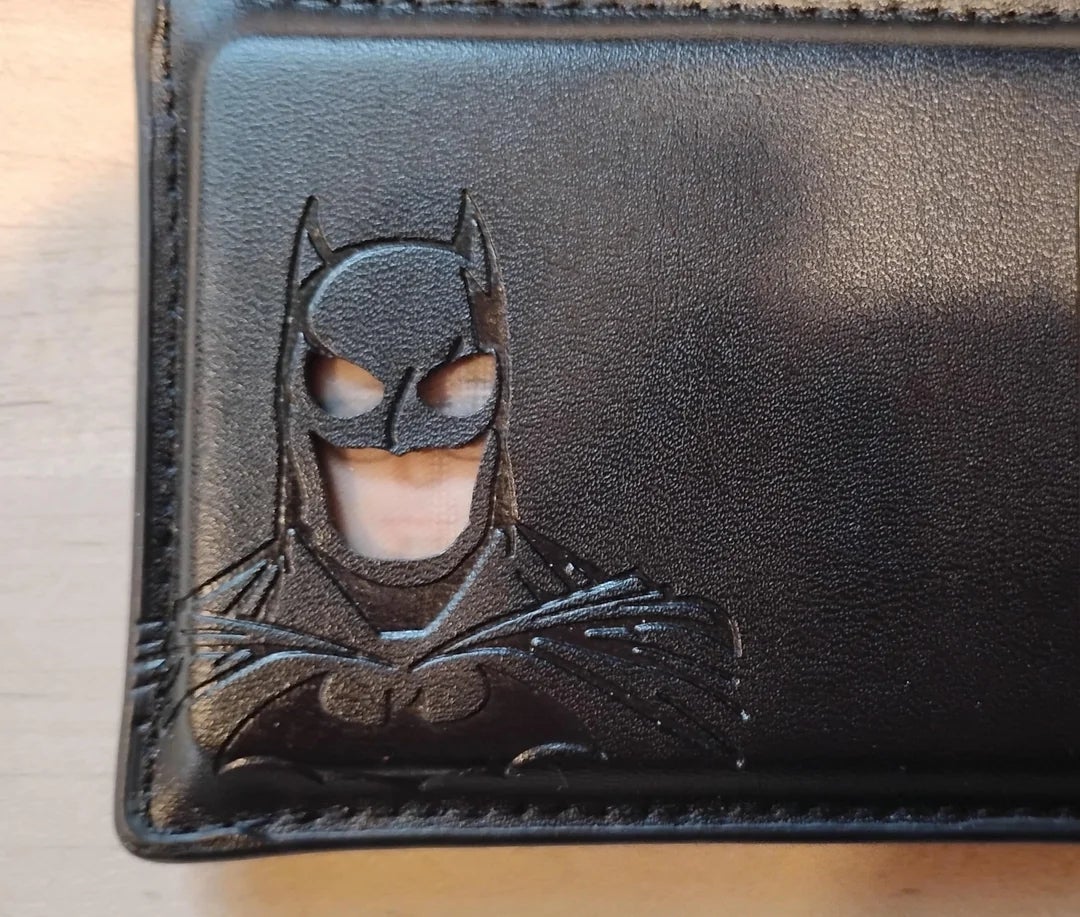 Leather wallet with embossed Batman design, showcasing his iconic disguise  and thorax  logo