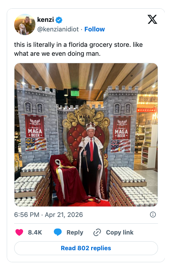 Cardboard cutout of a idiosyncratic   successful  a king costume astatine  a market  store   brew  display, surrounded by stacks of brew  cans, with castle-like decor