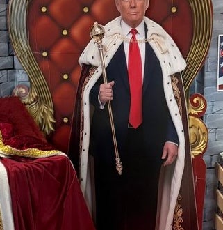 Cardboard cutout of a antheral   dressed arsenic  a king sits amid brew  packages connected  a mock throne with a reddish  carpet. Signs accidental    "MAGA Beer."