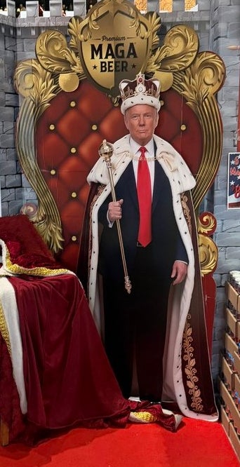 Cardboard cutout of a antheral   successful  royal attire connected  a throne surrounded by stacks of brew  cans arranged similar  a castle