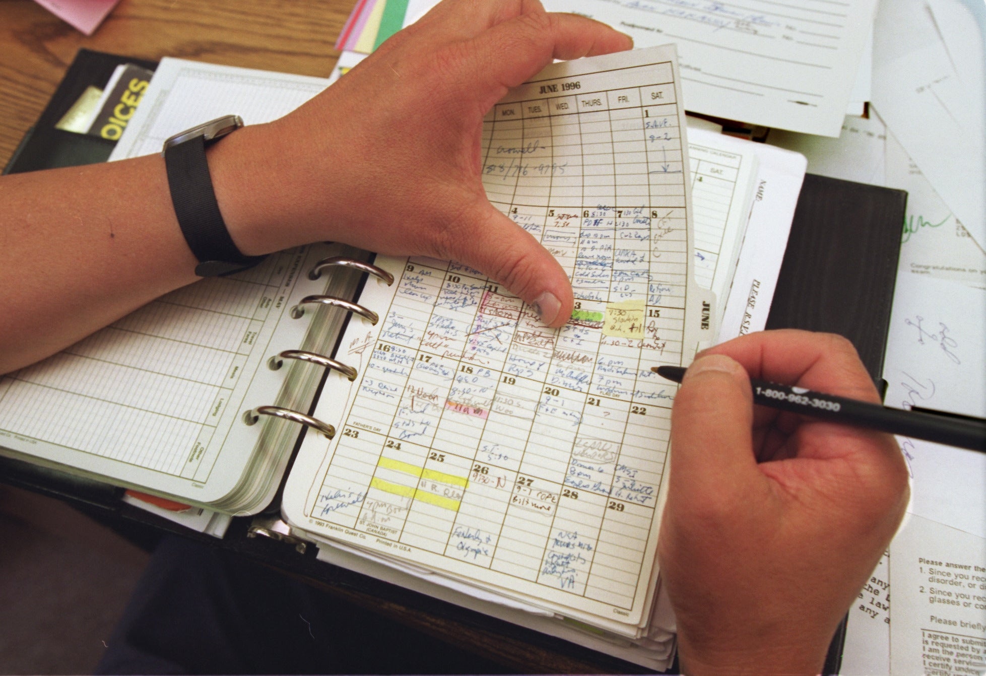 Person penning  successful  a elaborate  planner with handwritten notes and dates