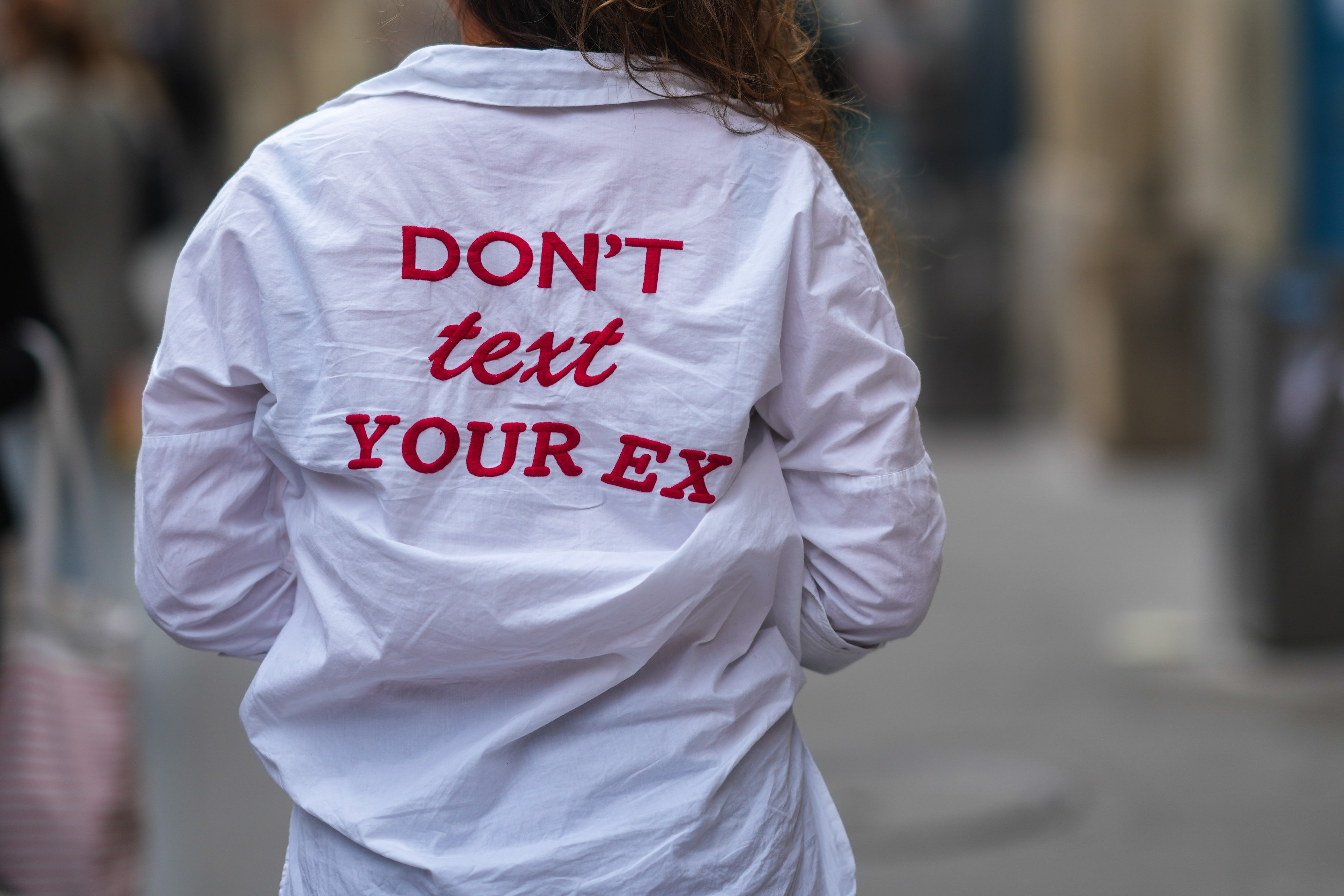 Person wearing a garment  with the text, "DON'T substance   YOUR EX," printed connected  the back
