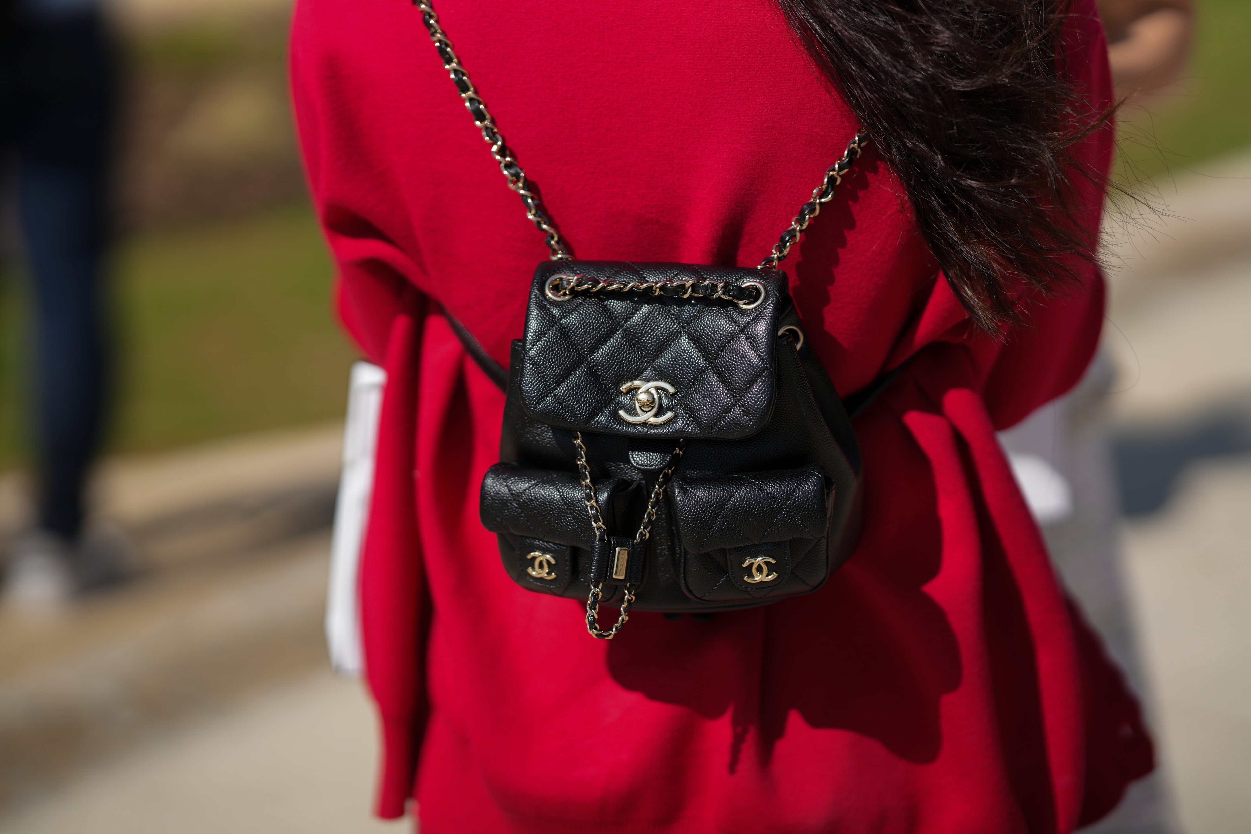 A idiosyncratic   wearing a stylish Chanel quilted backpack with golden  concatenation  straps