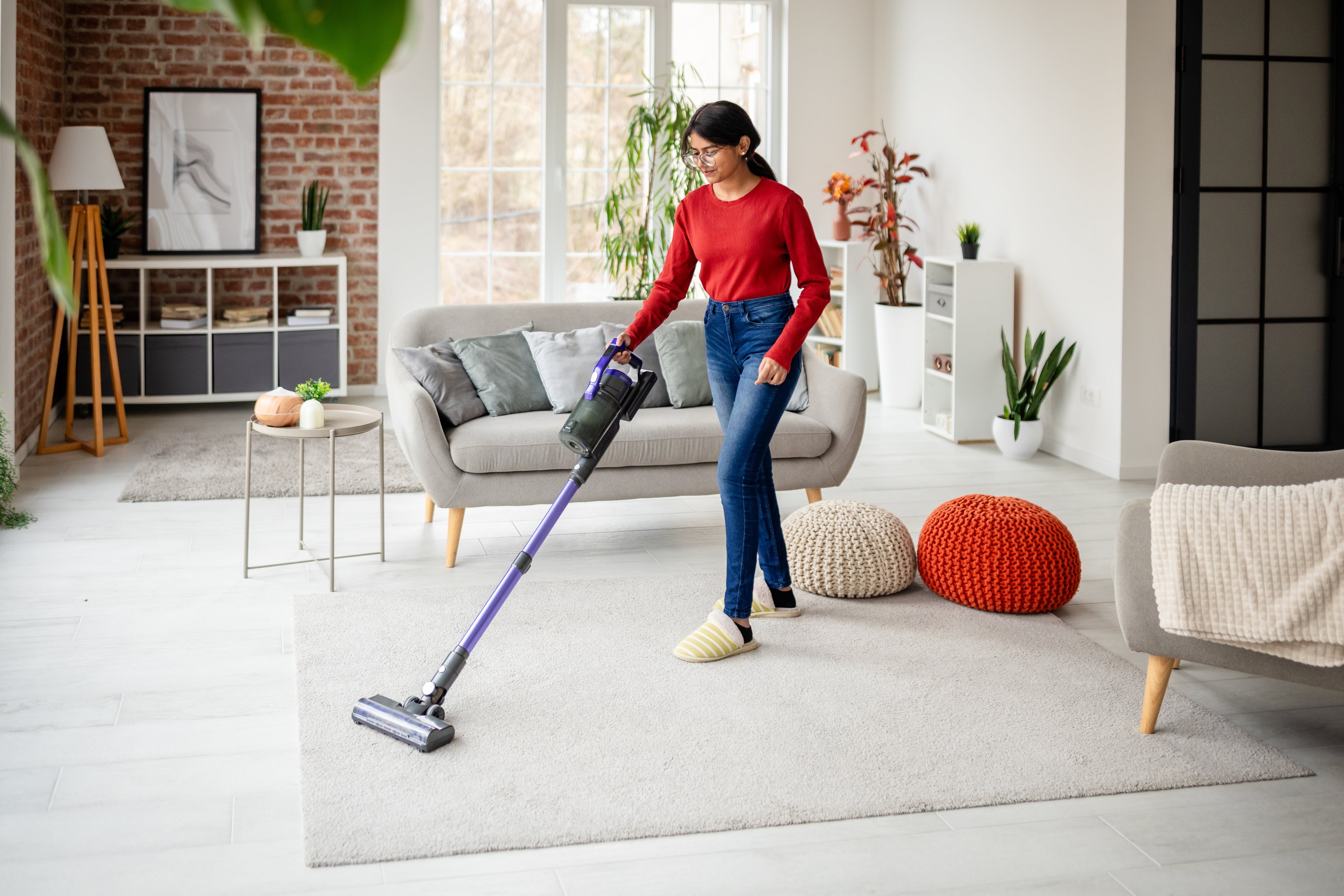 Person successful  casual attire vacuuming a modern   surviving  country   with a ample  model   and stylish decor