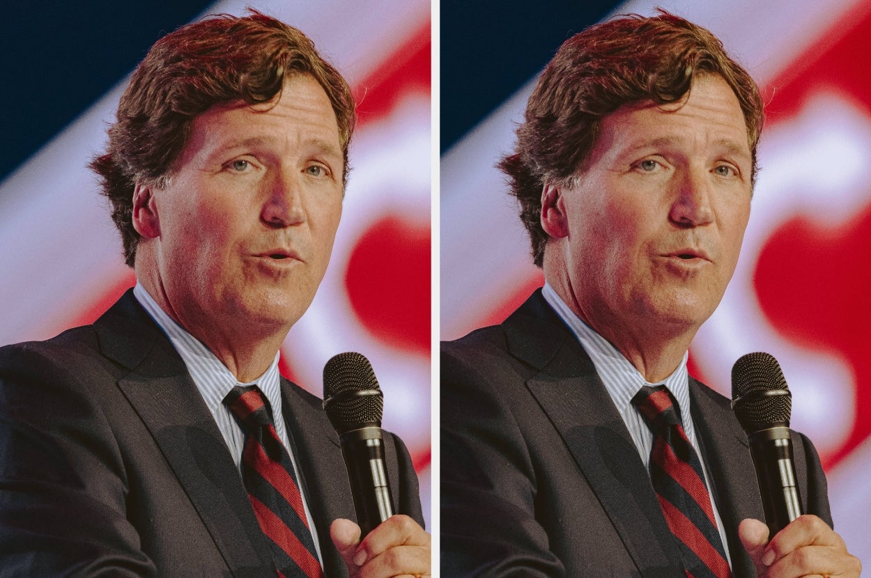 A man in a suit and tie speaks into a microphone at a public event