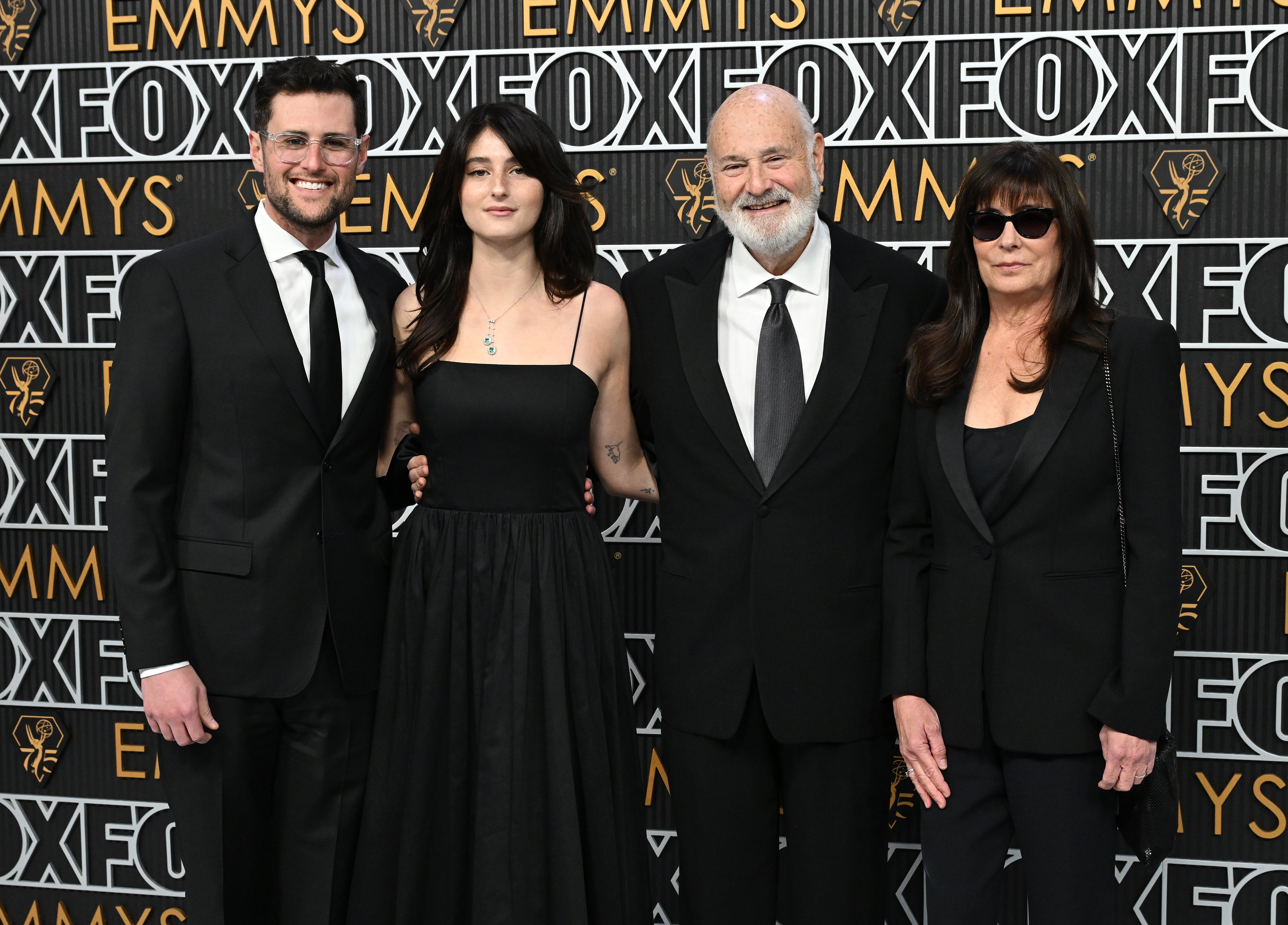 Four radical   airs  successful  elegant achromatic  attire connected  the Emmys reddish  carpet. Background features "Emmys" and "Fox" logos