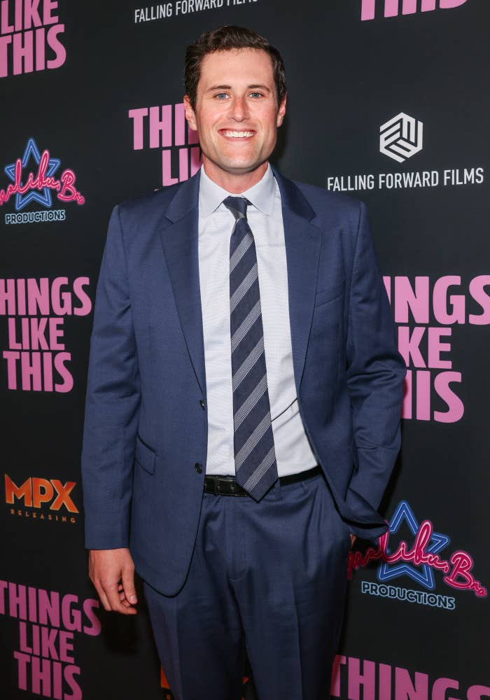 Person successful  a suit   with a striped necktie  astatine  a movie  premiere backdrop featuring "Things Like This" repeated text