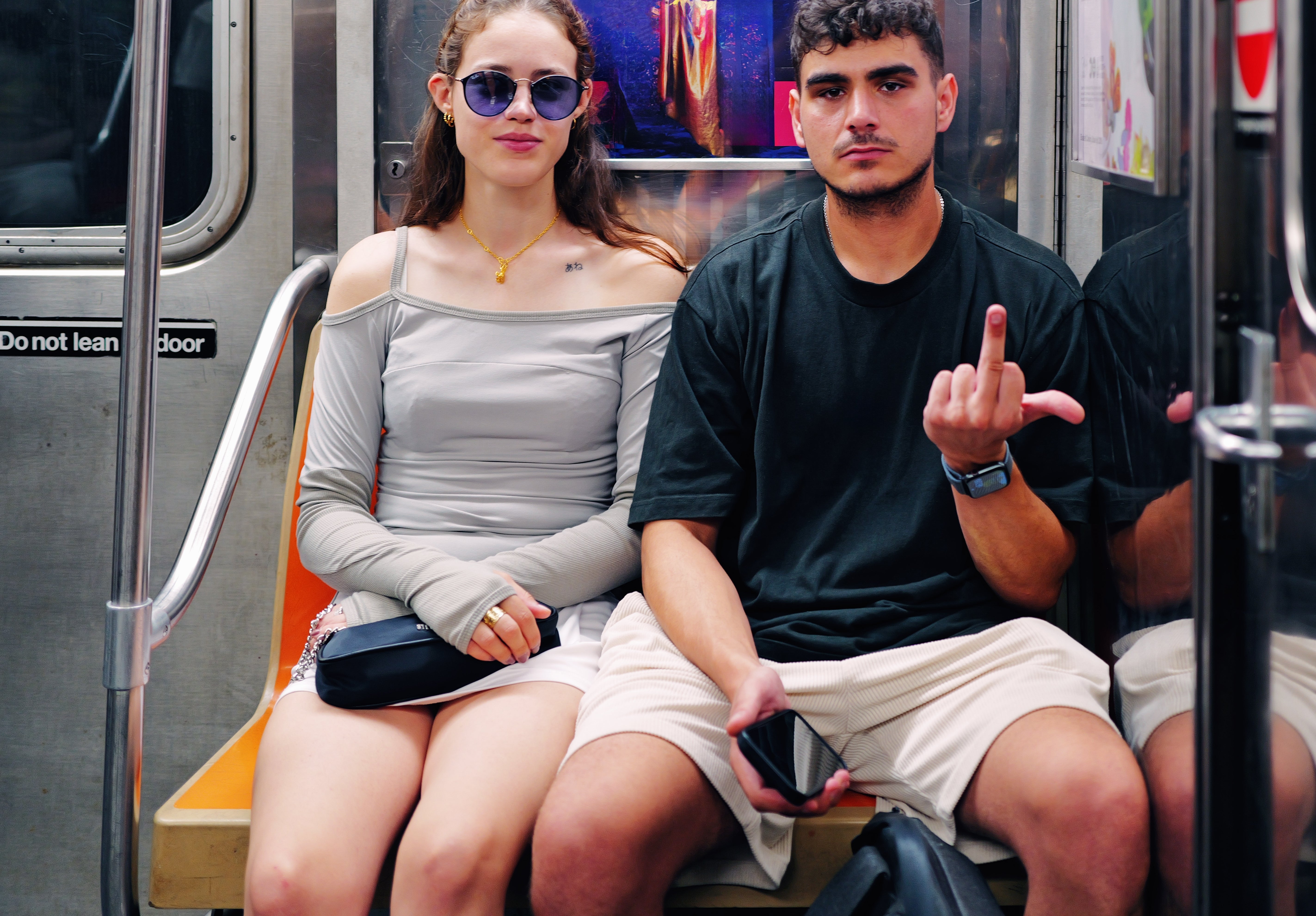Two radical   beryllium   connected  a subway. The idiosyncratic   connected  the near  wears sunglasses and an off-shoulder top. The idiosyncratic   connected  the close    makes a manus  gesture