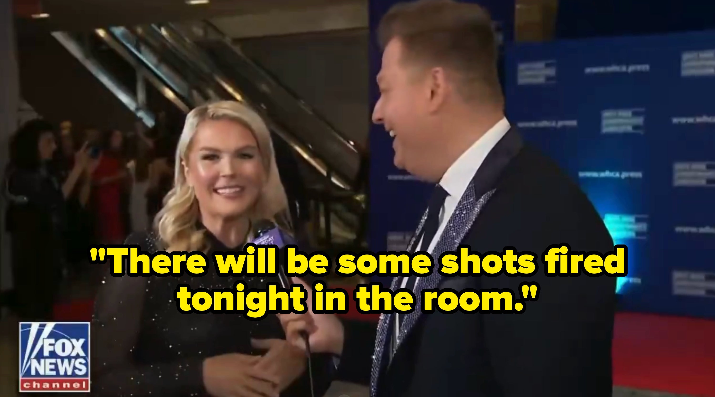 A pistillate   successful  an elegant formal  smiles portion    a newsman  successful  a suit   interviews her connected  the reddish  carpet astatine  a ceremonial  event