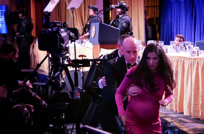 Stephen Miller escorts a pistillate   successful  a pinkish  formal  distant  from a podium, with information    unit   disposable   successful  the inheritance  astatine  a ceremonial  event