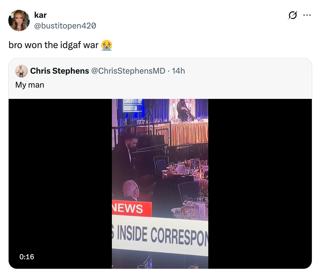 Screenshot of a tweet showing a person sitting at an empty table during a news event with caption, "bro won the idgaf war."