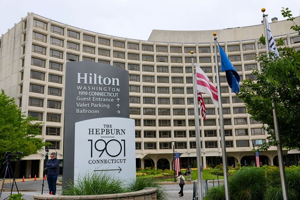 Utsikt over Hilton Hotel i Washington DC med skilting for gjesteinngang, betjent og ballsal. To personer står nær inngangen