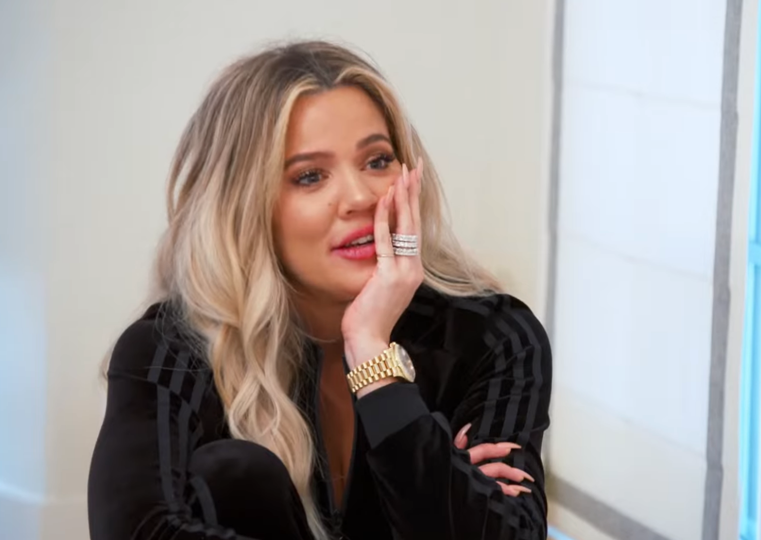 Khloe Kardashian with agelong  wavy hairsbreadth  and a thoughtful look  wears an outfit, a watch, and rings, resting her look   connected  her hand