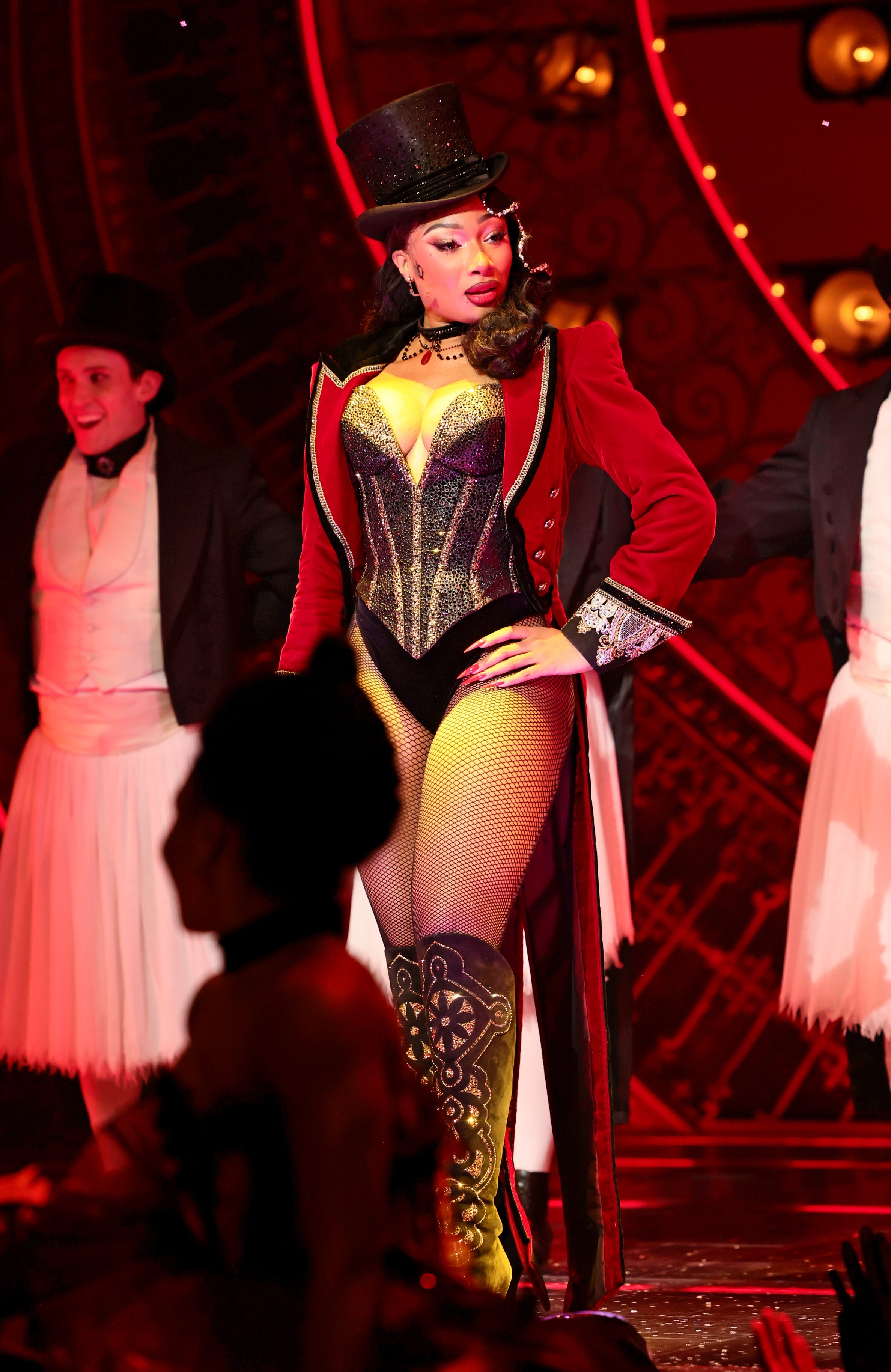 Megan Thee Stallion successful  a showgirl-inspired corset, fishnet stockings, and a apical  chapeau  connected  signifier    with dancers, evoking a cabaret style