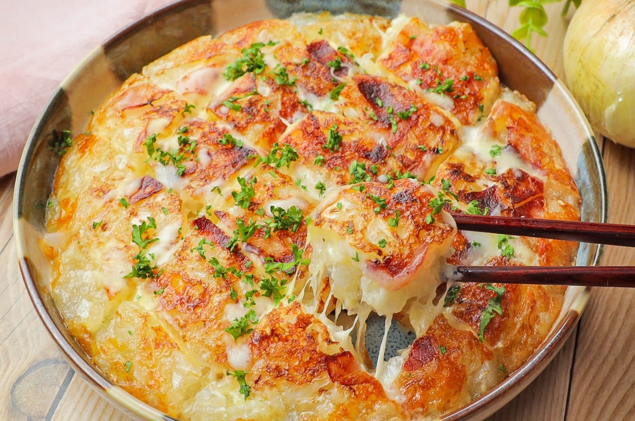 料理の写真。焼き色のついたチーズがかけられたディッシュが箸で持ち上げられています。