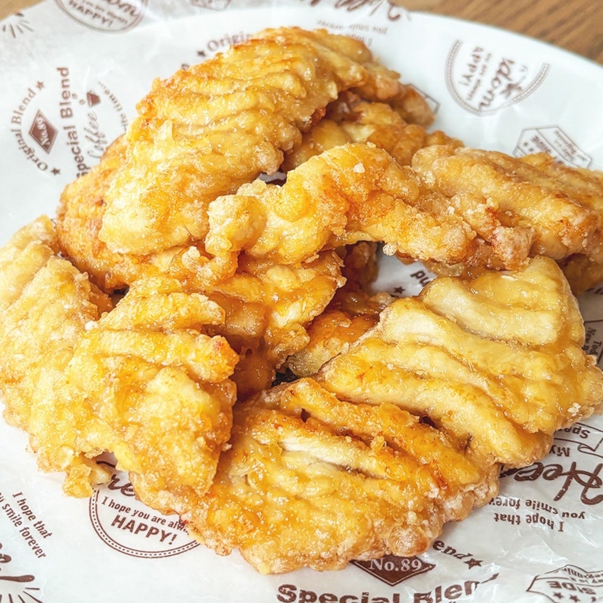 紙の上に揚げた鶏肉の唐揚げが数個盛られている。