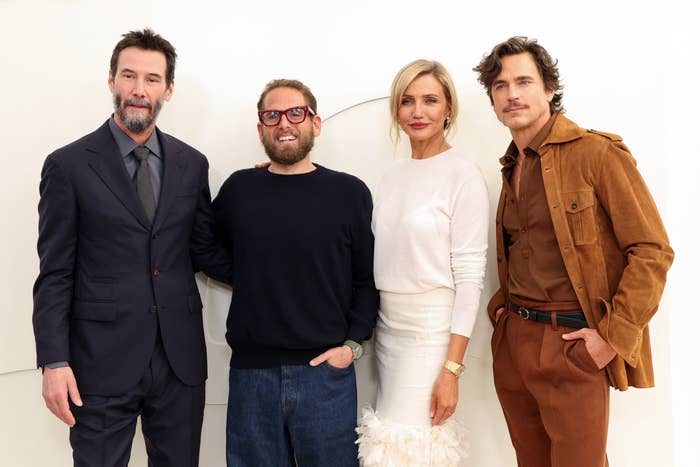 Four radical   airs  together, dressed successful  ceremonial  and smart-casual attire; 2  men successful  suits, 1  successful  a sweater, and a pistillate   successful  an elegant dress