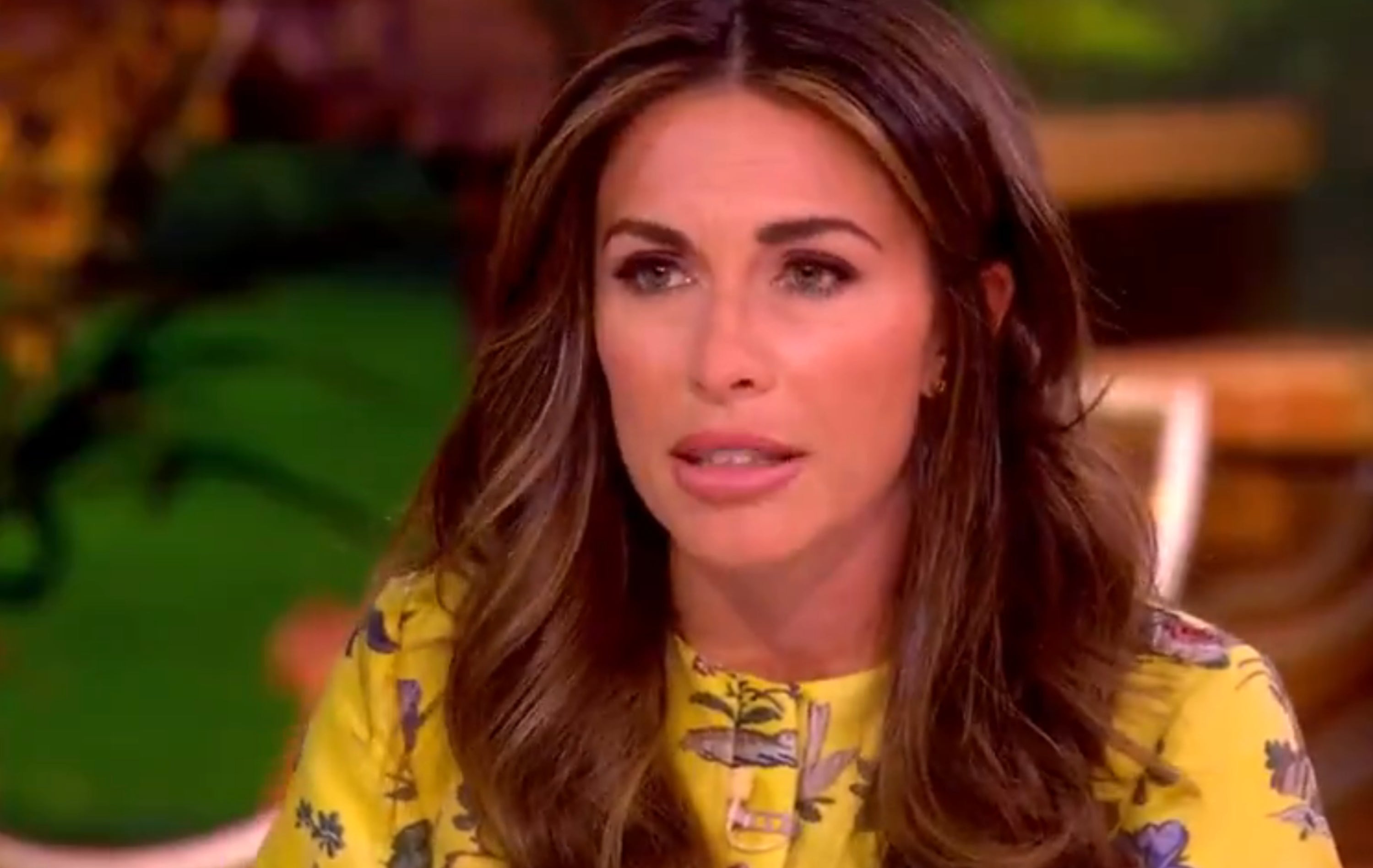 A idiosyncratic   with agelong  hairsbreadth  wearing a floral-patterned formal  speaks connected  a speech   amusement   set