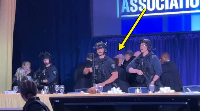 Several instrumentality    enforcement officers successful  tactical cogwheel  basal   adjacent   a signifier    with a ample  surface  displaying partial substance   "ASSOCIATION."