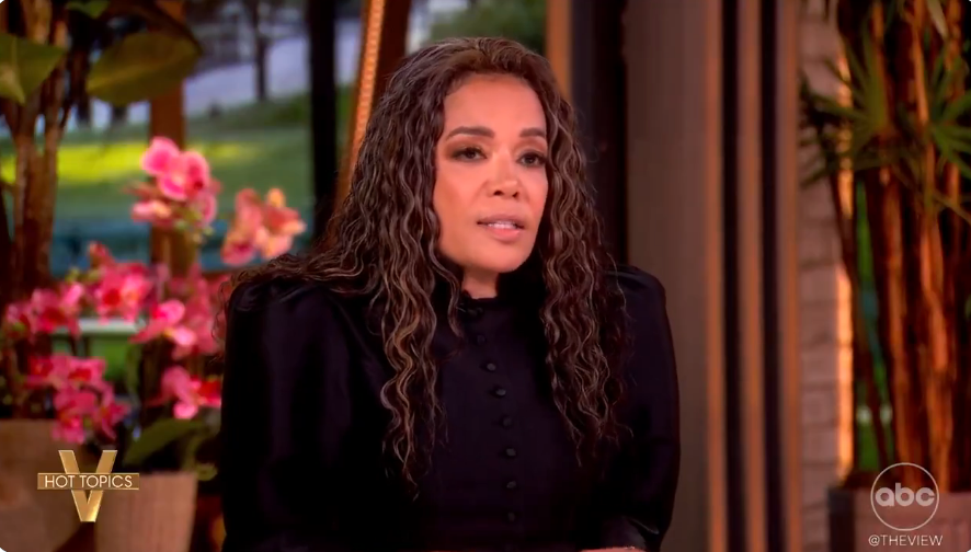 A idiosyncratic   connected  a speech   amusement   acceptable   with floral decorations, wearing a formal, buttoned top, speaking astir  existent   topics