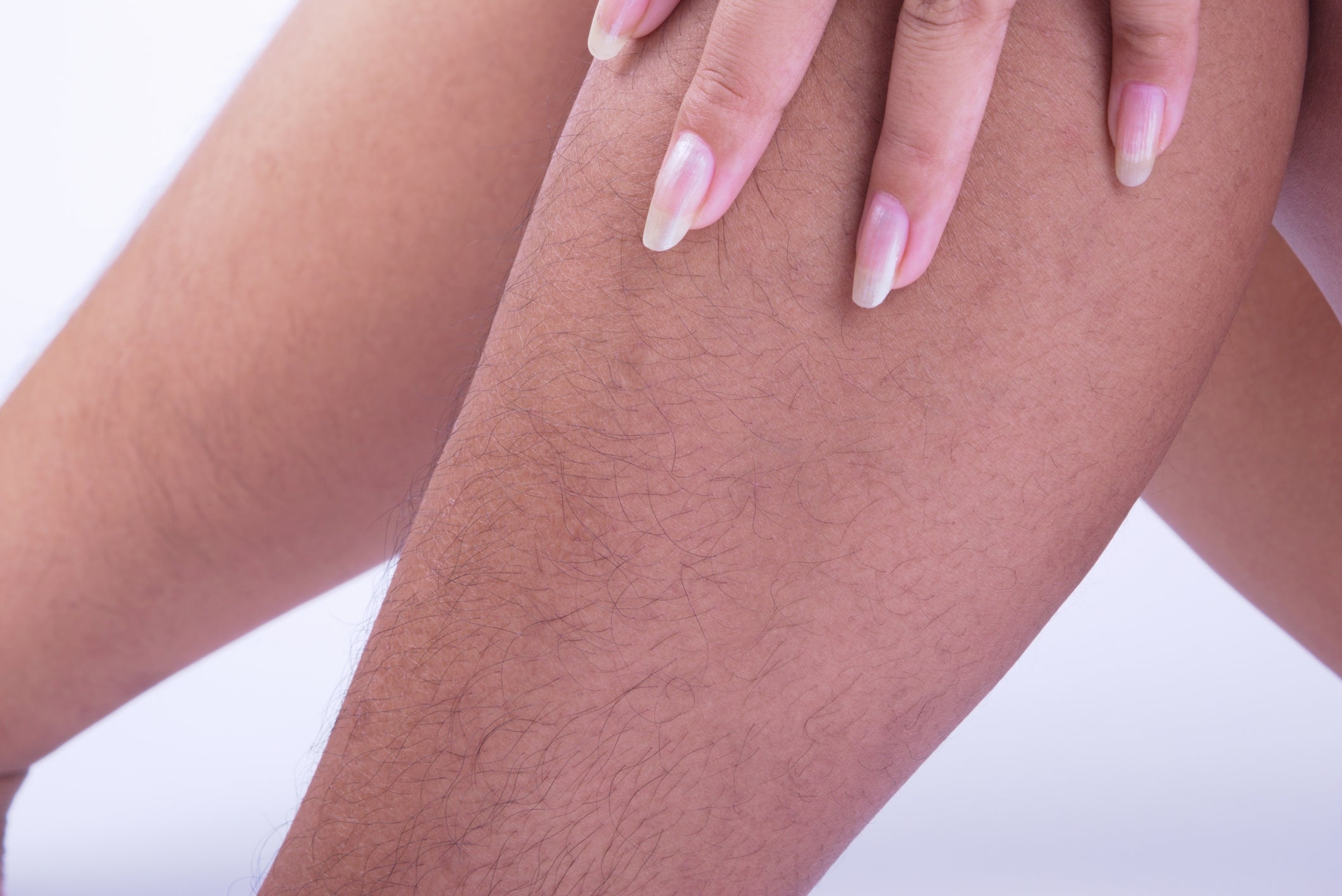 Close-up of a person's limb  with disposable   hairsbreadth  and nails mildly  touching it