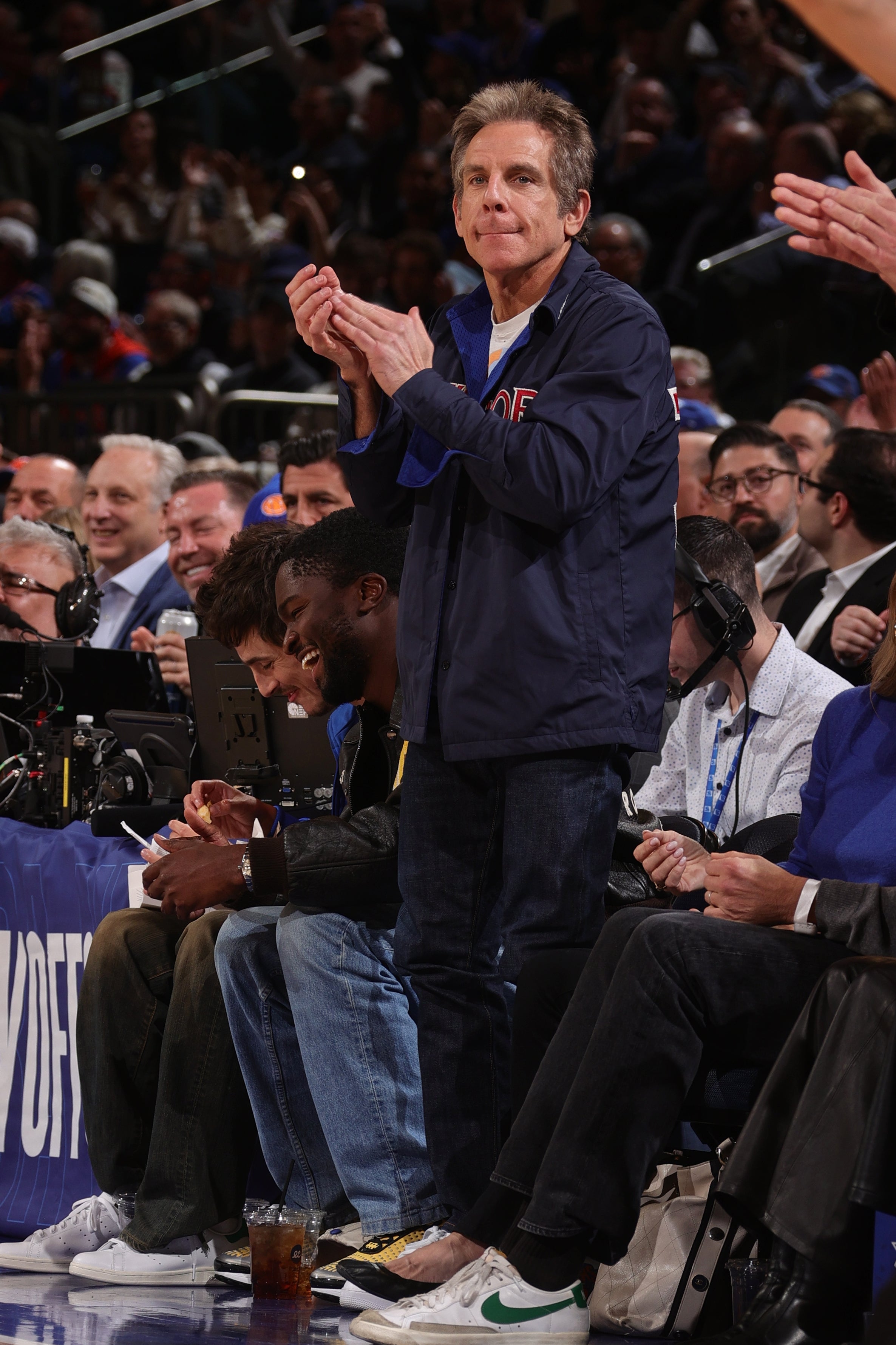 A idiosyncratic   claps astatine  a hoops  crippled  portion    others are seated nearby, showing involvement  successful  the ongoing event