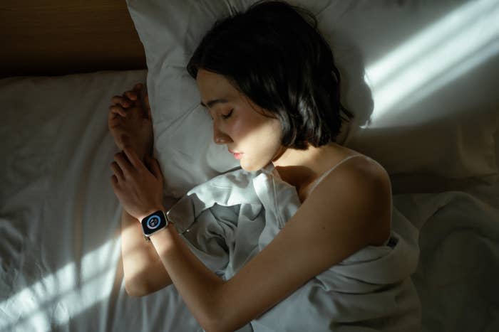 Person sleeping successful  furniture  wearing a smartwatch, with sunlight streaming crossed  them