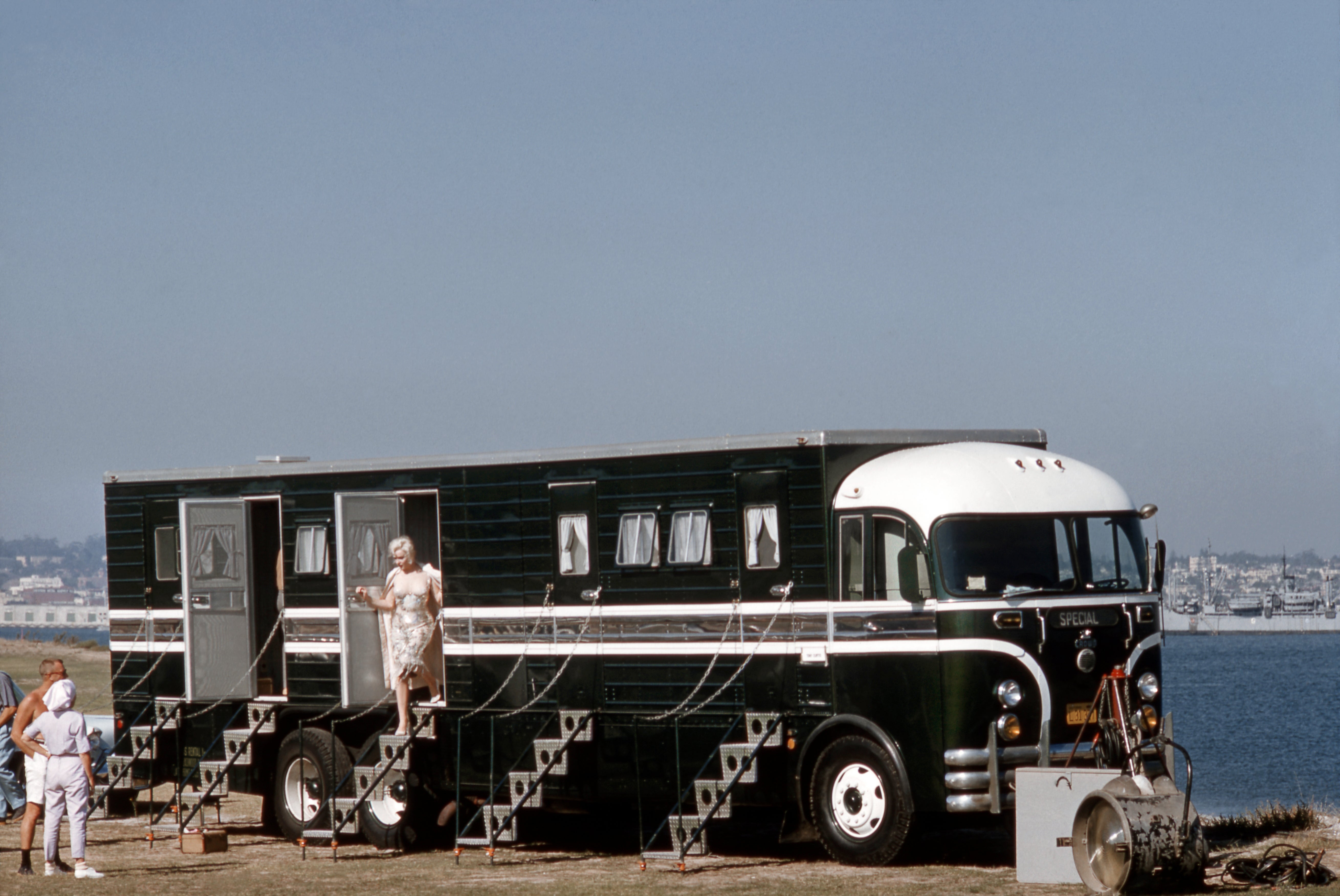 A idiosyncratic   exits a vintage trailer connected  a movie  acceptable   by the water, with others nearby