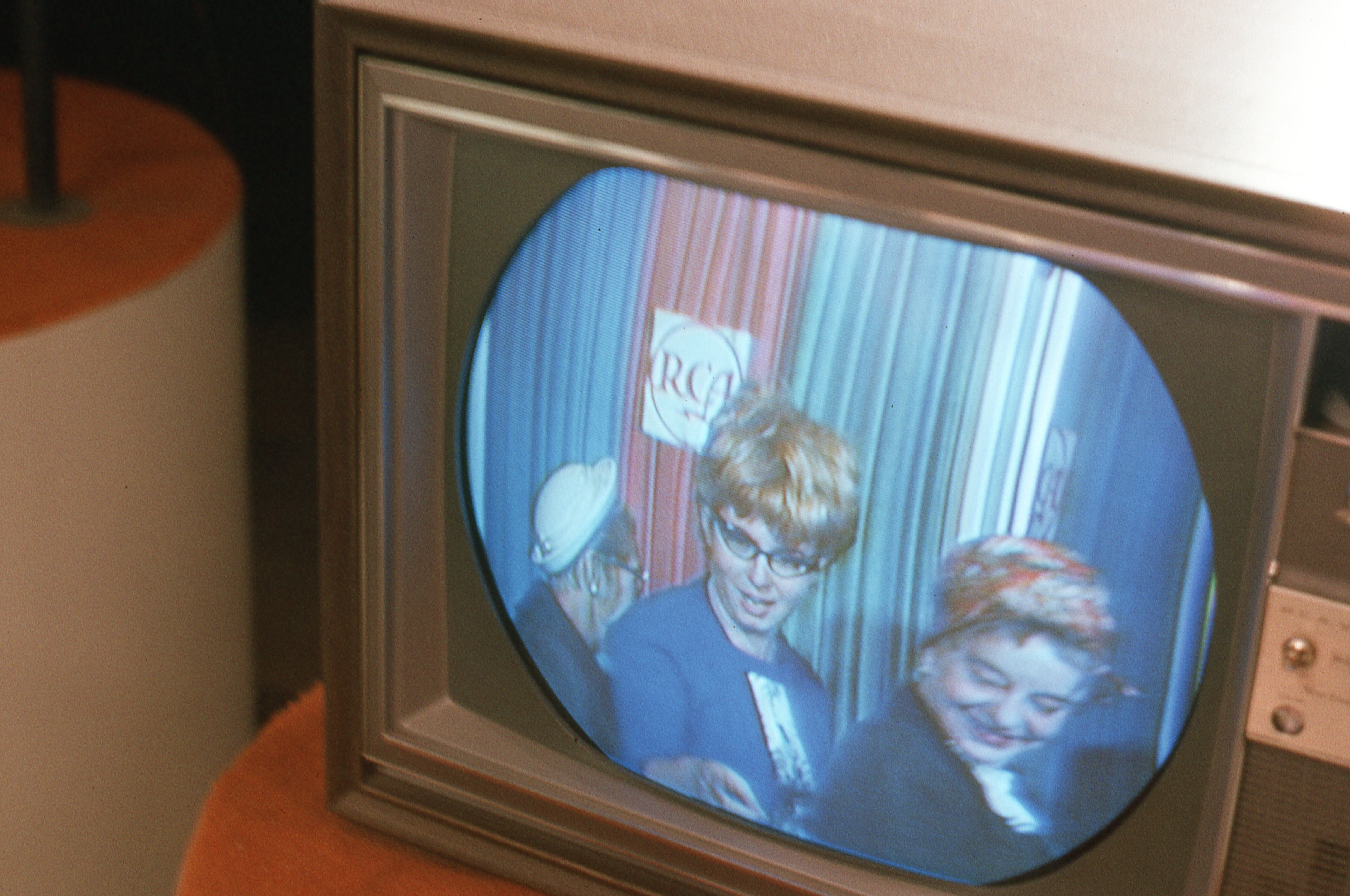 Image of a vintage tv  showing 2  individuals with retro hairstyles and clothing