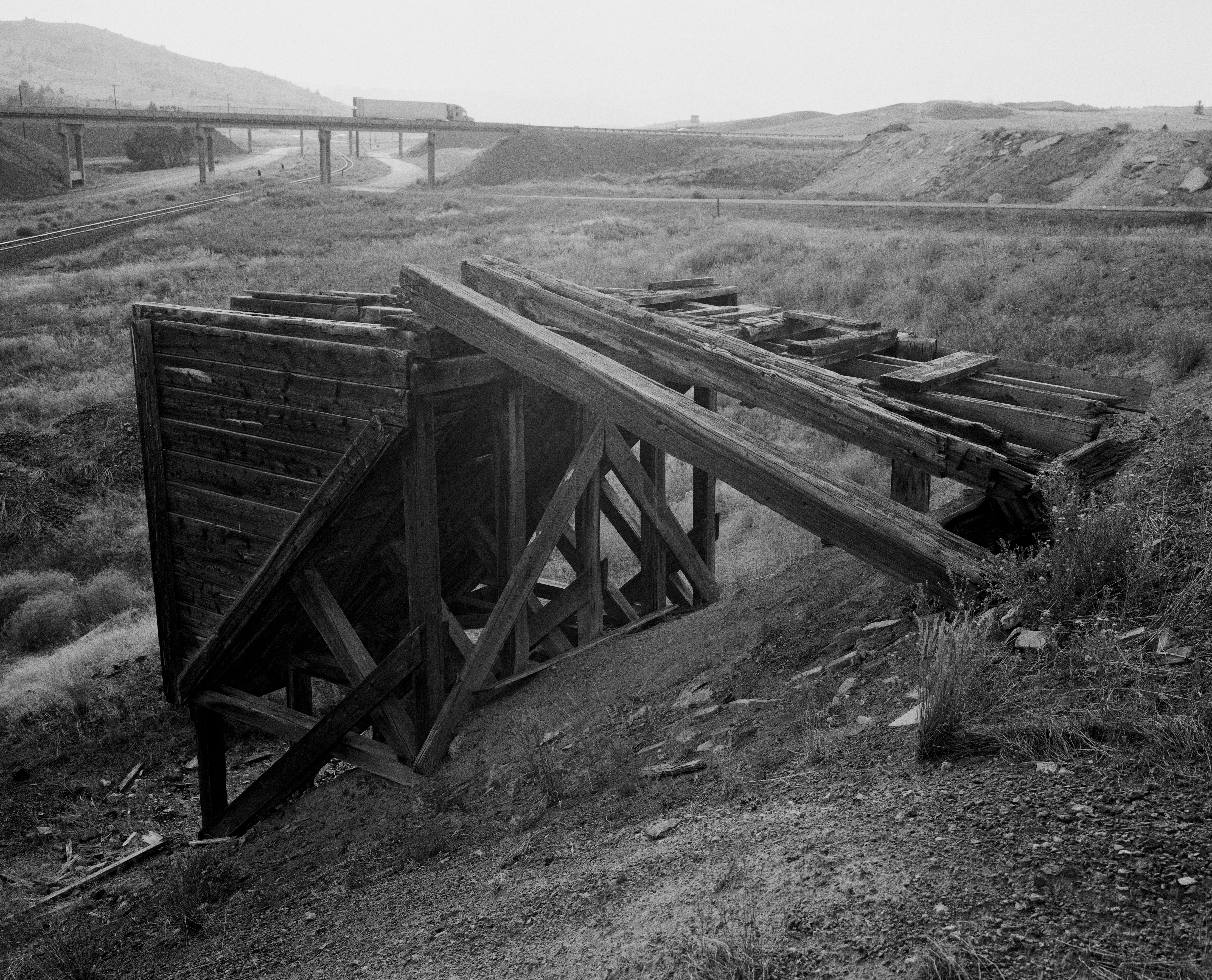Old woody  mining operation   connected  a elevation  with span  and motortruck  successful  the background, evoking a humanities  concern   landscape
