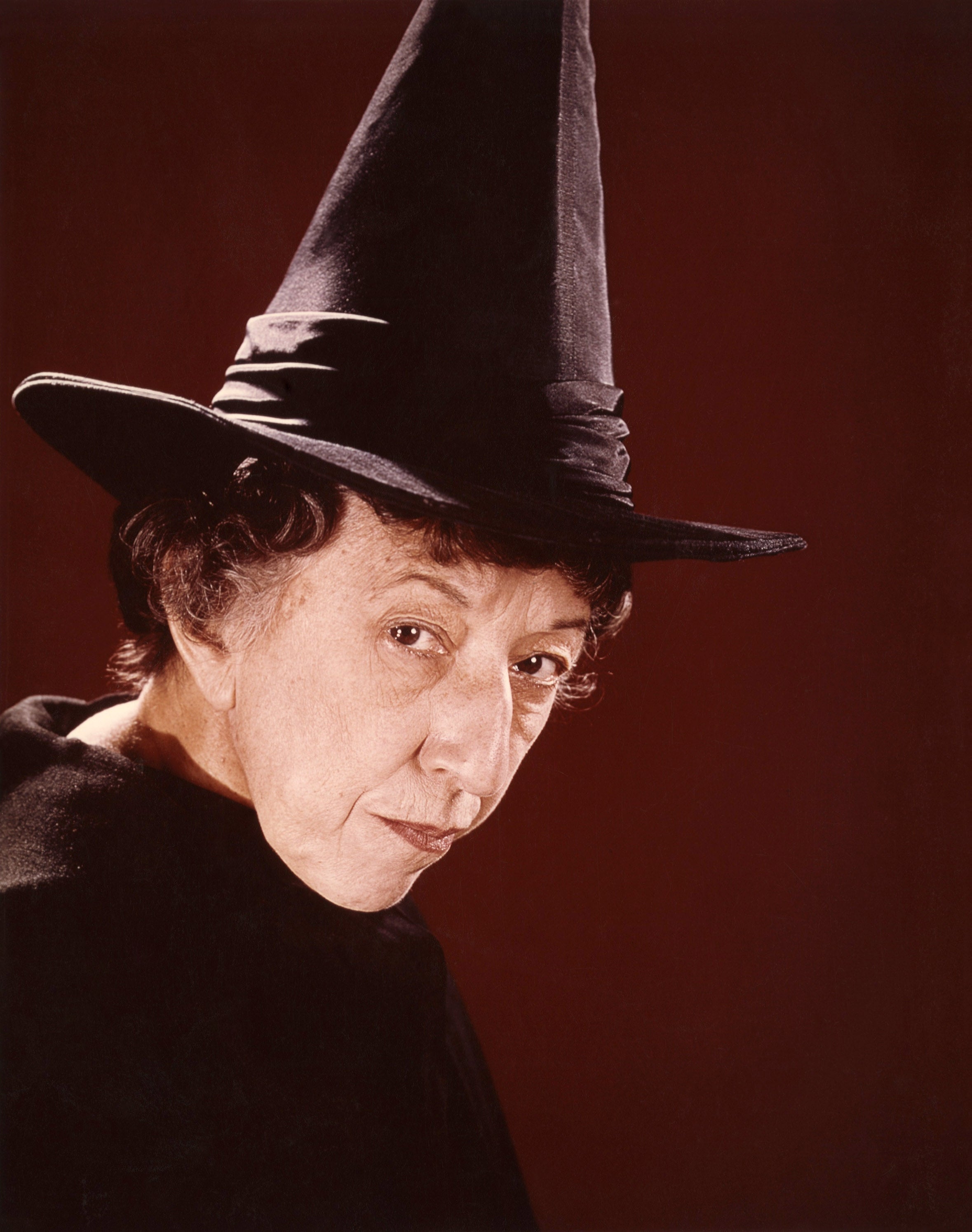 Person wearing a pointed witch hat, looking implicit    their enarthrosis  with a superior   expression