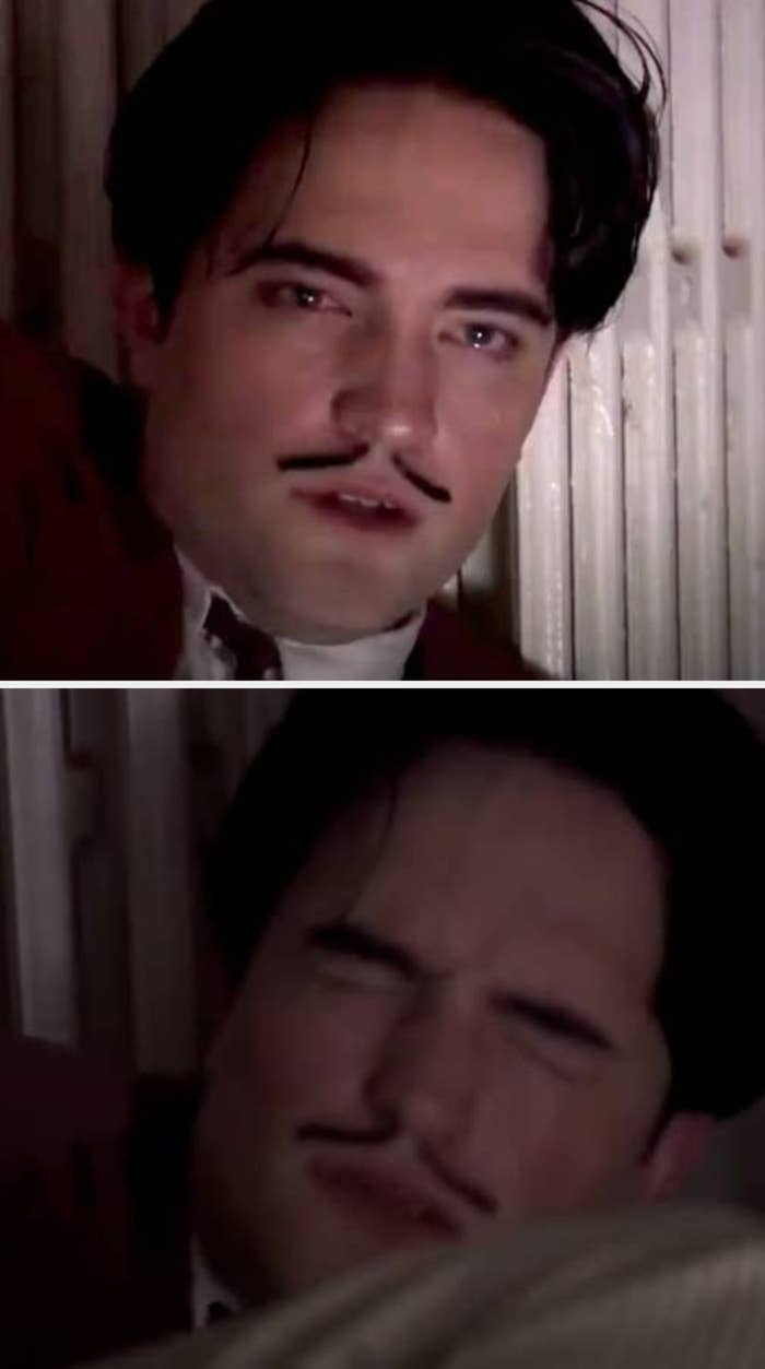 Robert Pattinson in a Little Ashes scene with styled dark hair and mustache, wearing a suit, posing against a textured wall