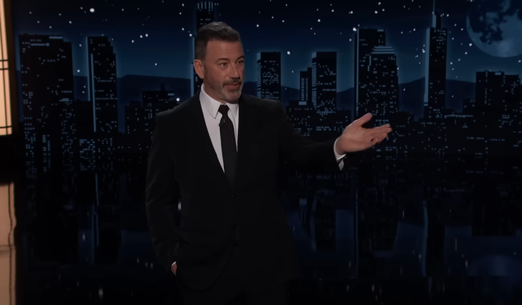 A idiosyncratic   successful  a suit   delivers a monologue connected  a nighttime speech   amusement   acceptable   with a cityscape backdrop