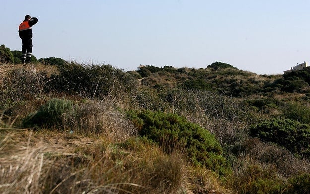 Person lasting  connected  a grassy hillside looking into the region  with binoculars