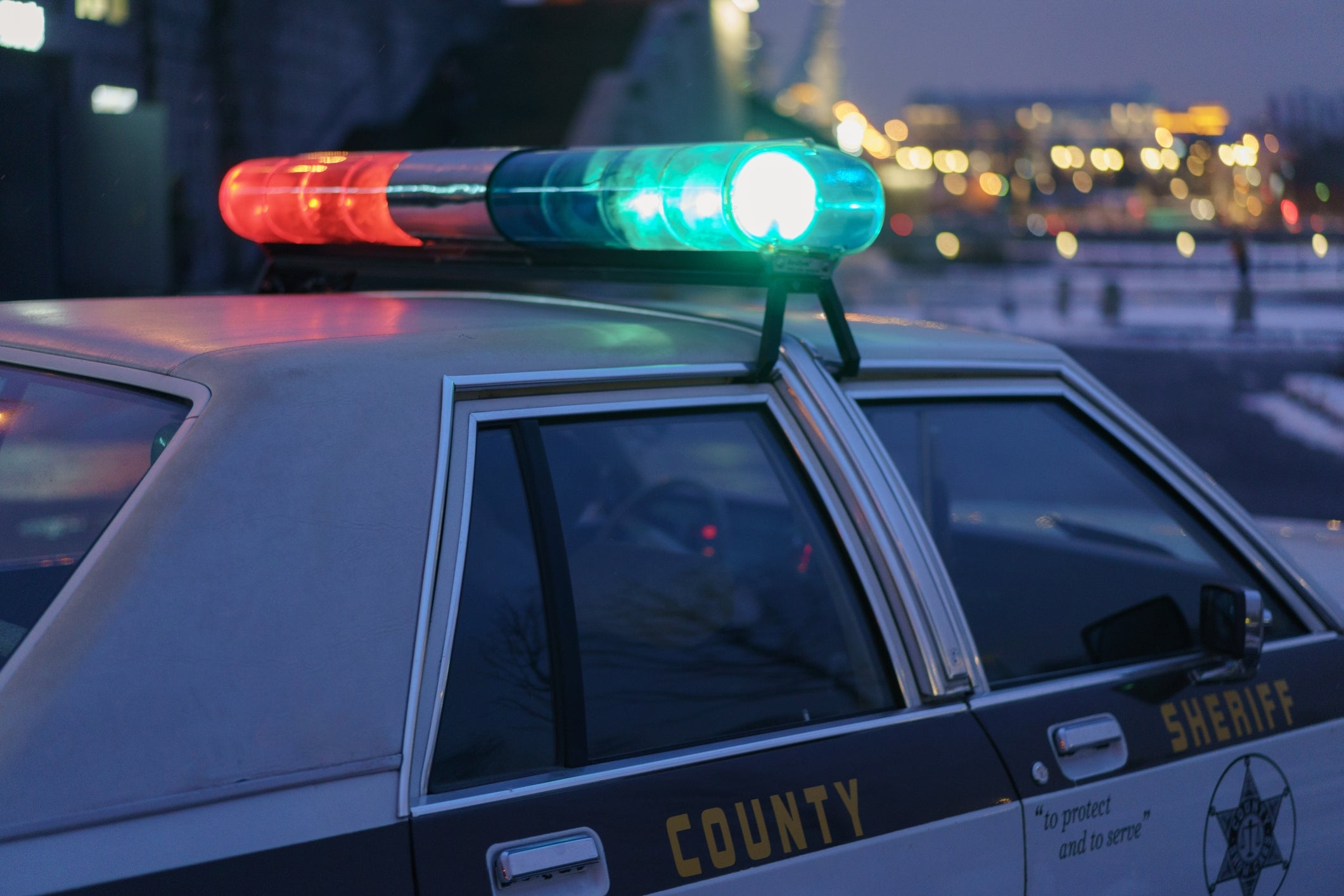Sheriff's car   with flashing lights parked astatine  night