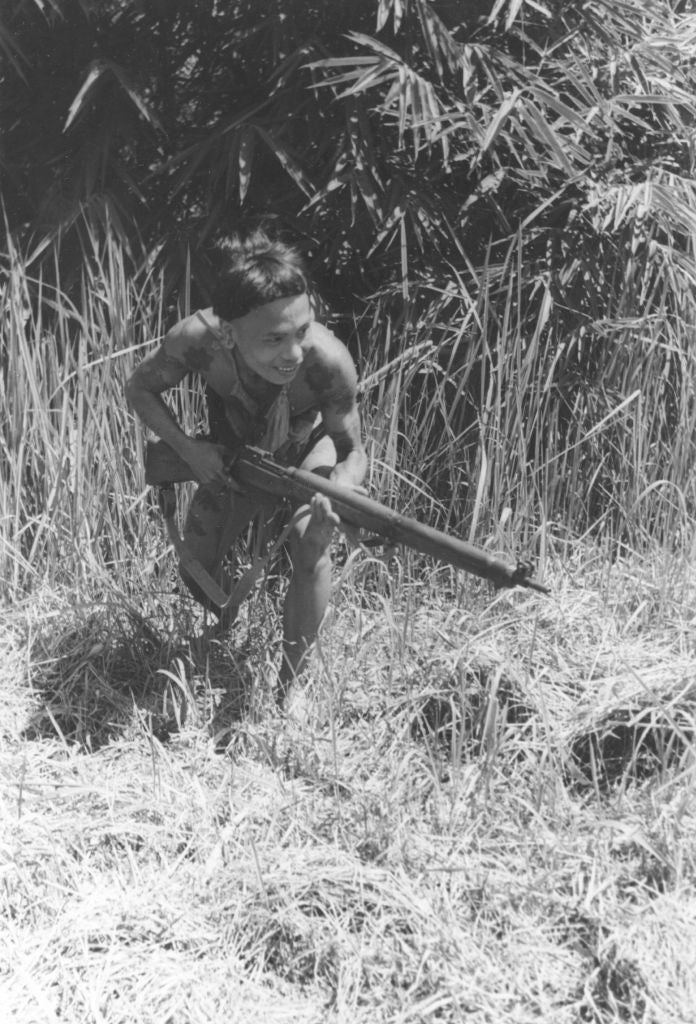 Person successful  dense writer  holding a rifle, wearing minimal clothing, appears cautious
