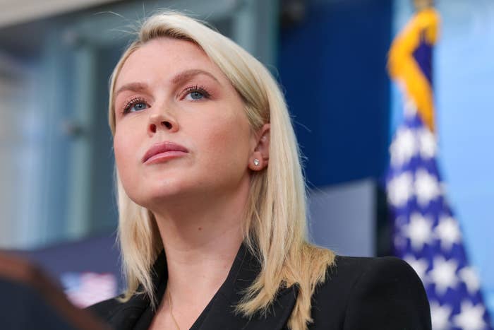 Person successful  a ceremonial  setting, wearing a achromatic  blazer, looking upwards with a emblem  successful  the background