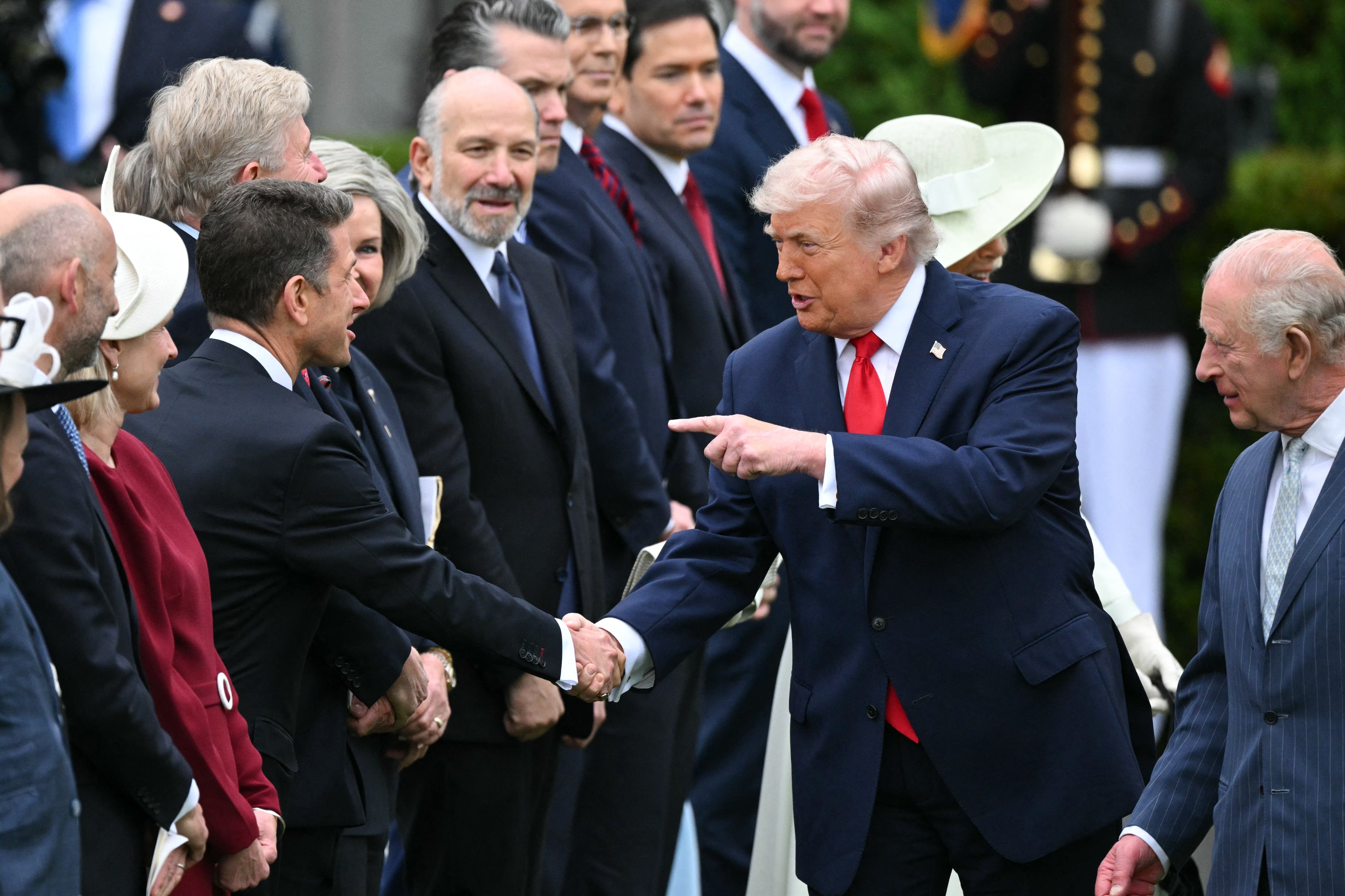 Donald Trump peker på noen mens han går nedover en mottakslinje