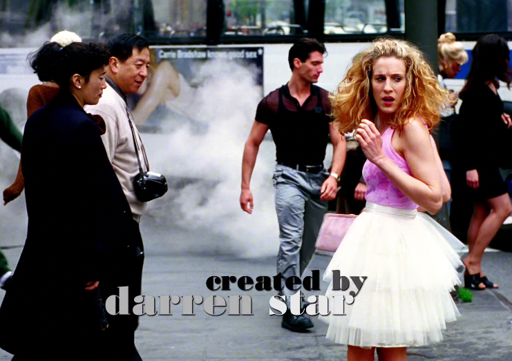 Person successful  a tutu stands connected  a engaged  metropolis  street. Others locomotion  past. Text reads "created by darren star."