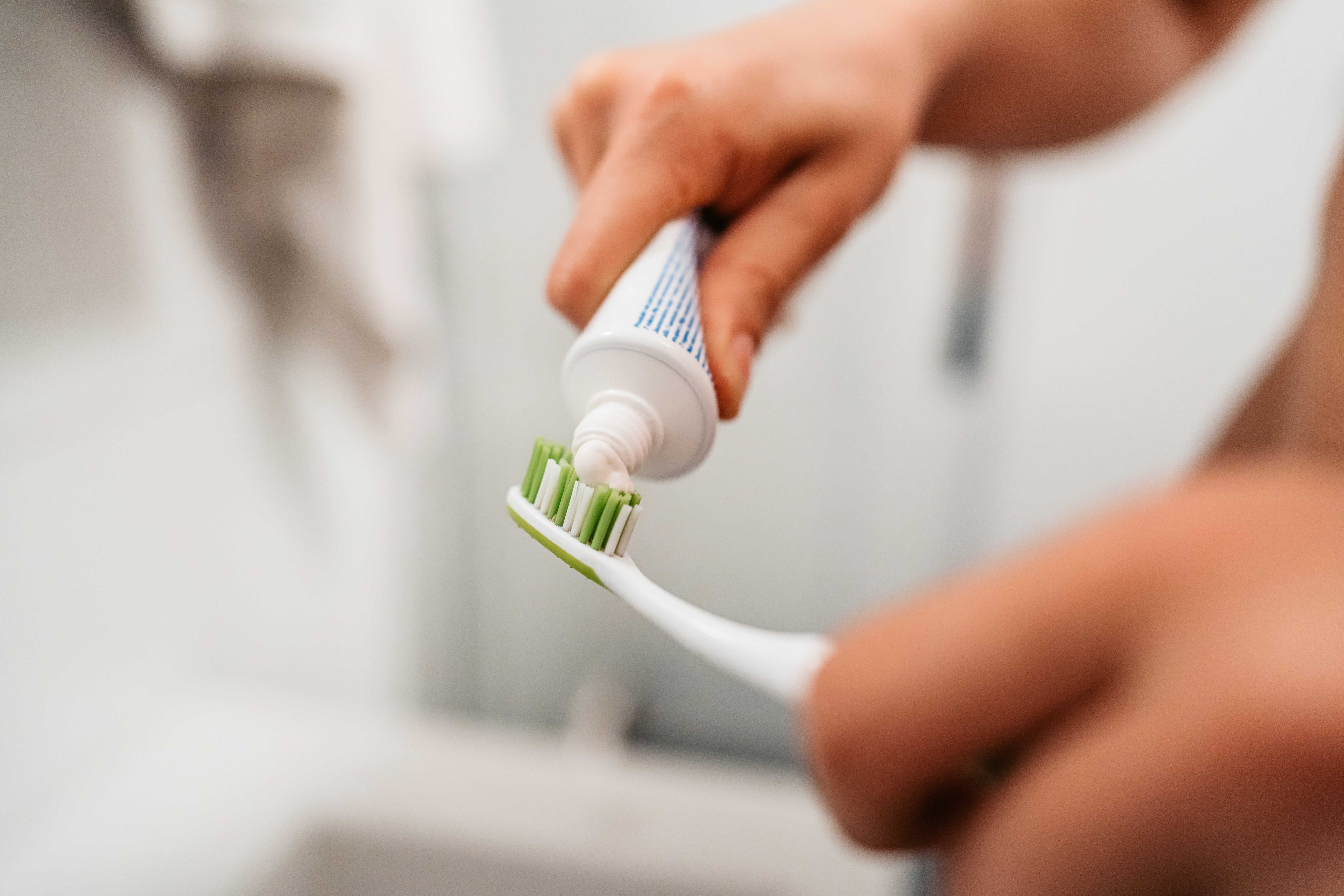 A idiosyncratic   applying toothpaste onto a toothbrush, emphasizing dental hygiene arsenic  portion  of a wellness  routine