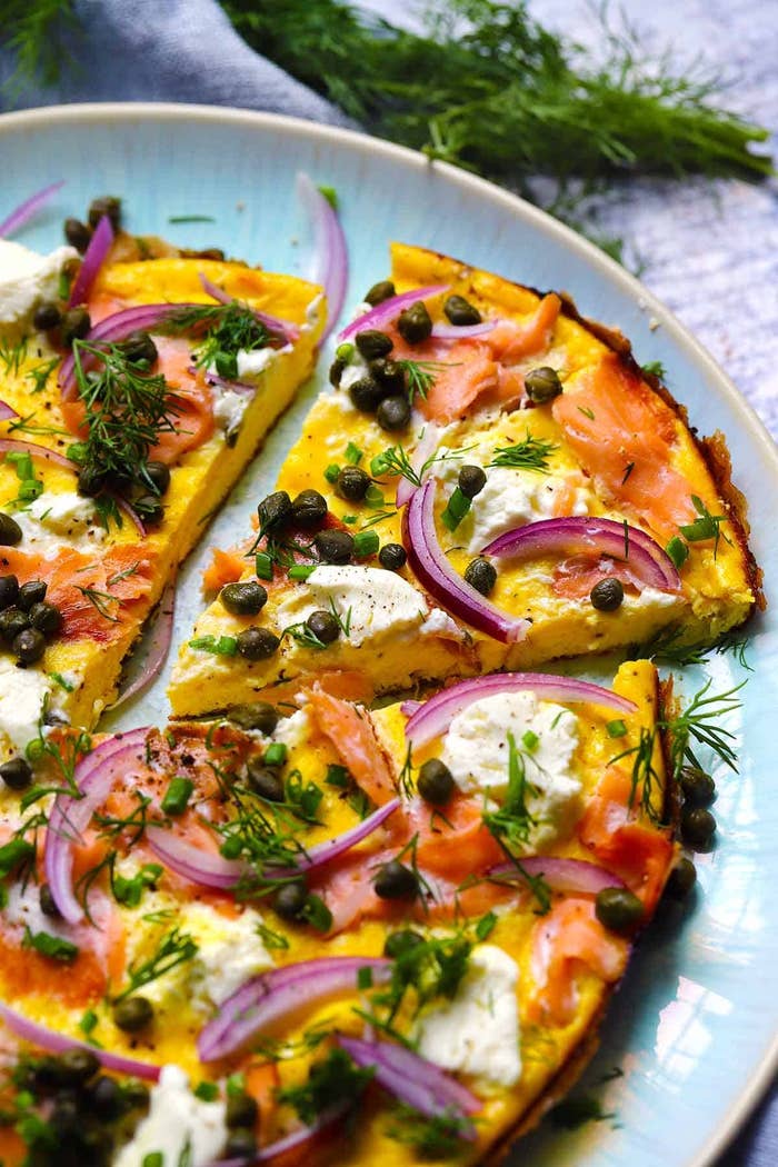 Pizza with smoked salmon, capers, red onions, dill, and cream cheese on a plate