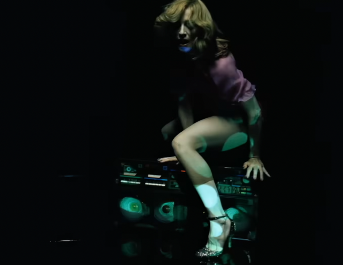 A idiosyncratic   poses dramatically implicit    a boombox successful  a dimly lit setting, wearing a stylish outfit with high-heeled shoes