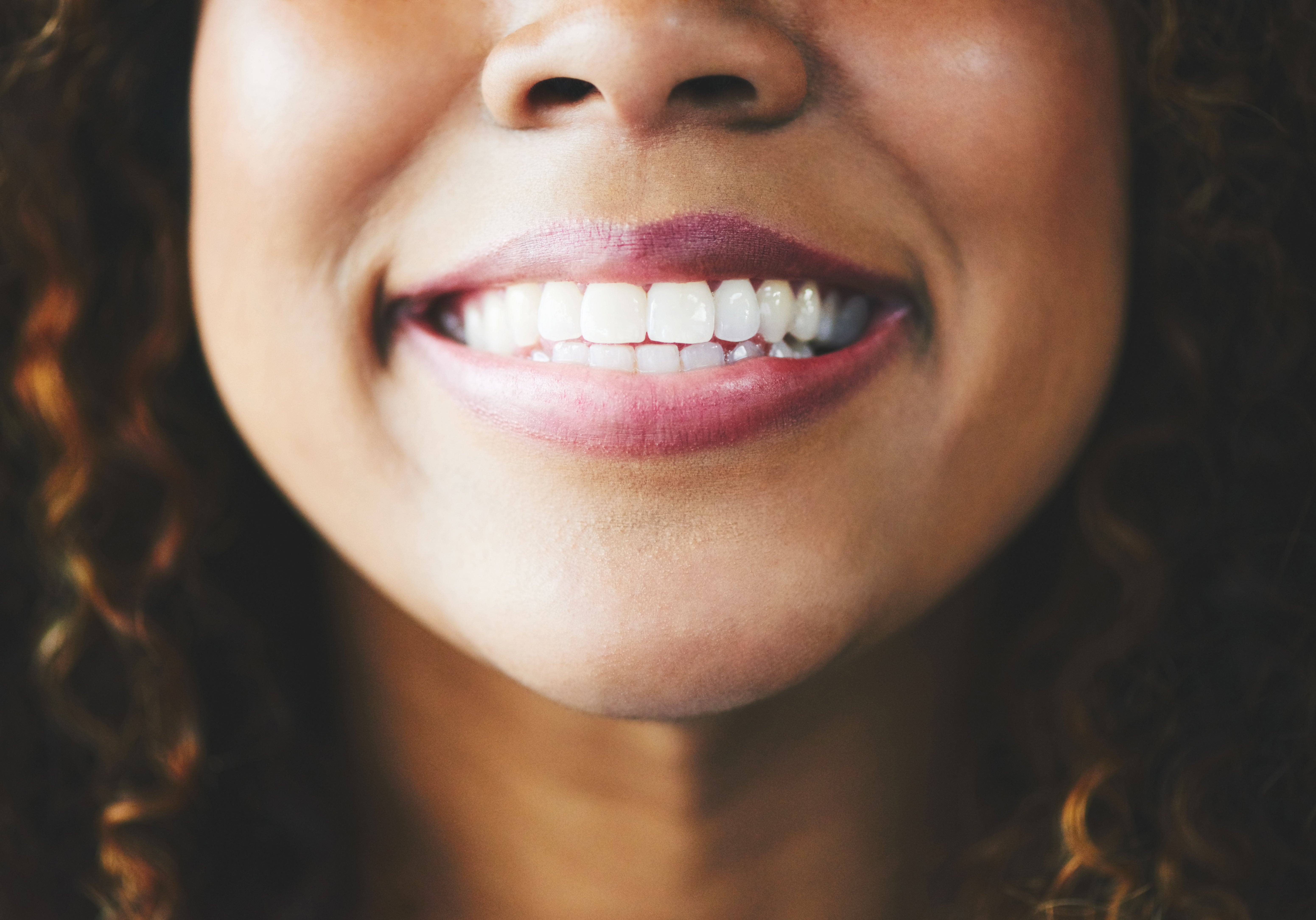 Person smiling brightly, showing teeth. The absorption   is connected  the mouth, emphasizing dental wellness  and hygiene