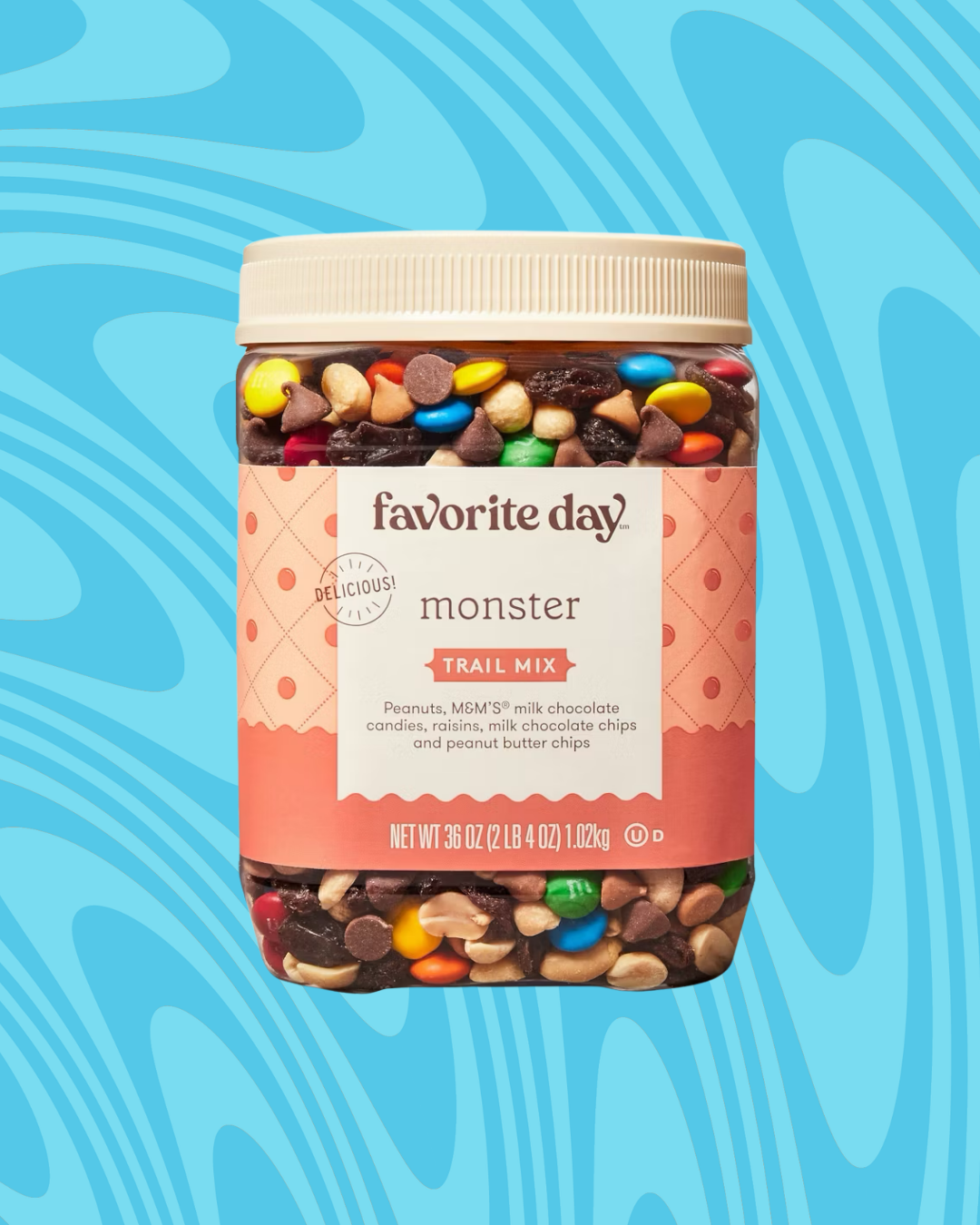Jar of trail mix with peanuts, milk chocolate candies, peanut butter chips, and semisweet chocolate chips against a blue swirled background