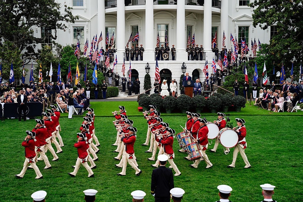 Colonial-dressed set  marches connected  White House lawn, with onlookers and officials connected  stage, symbolizing a ceremonial event