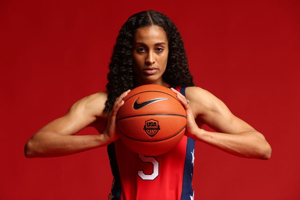 Person som holder en basketball, har på seg en sportstrøye med nummeret 