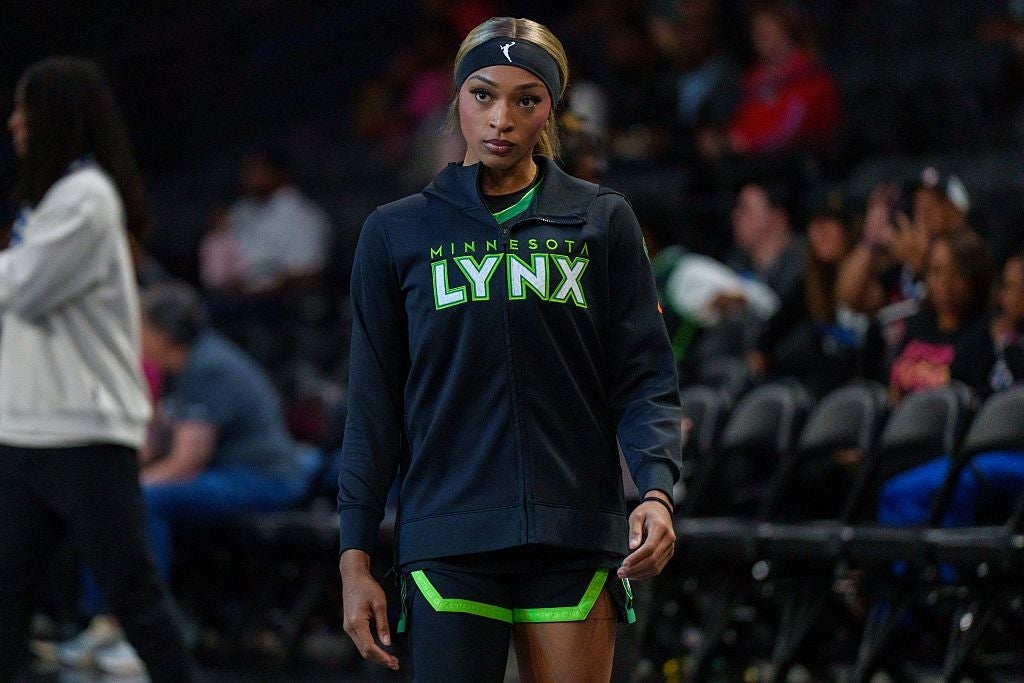 Person iført Minnesota Lynx atletisk utstyr som går på en basketballbane. Tilskuere er synlige i bakgrunnen