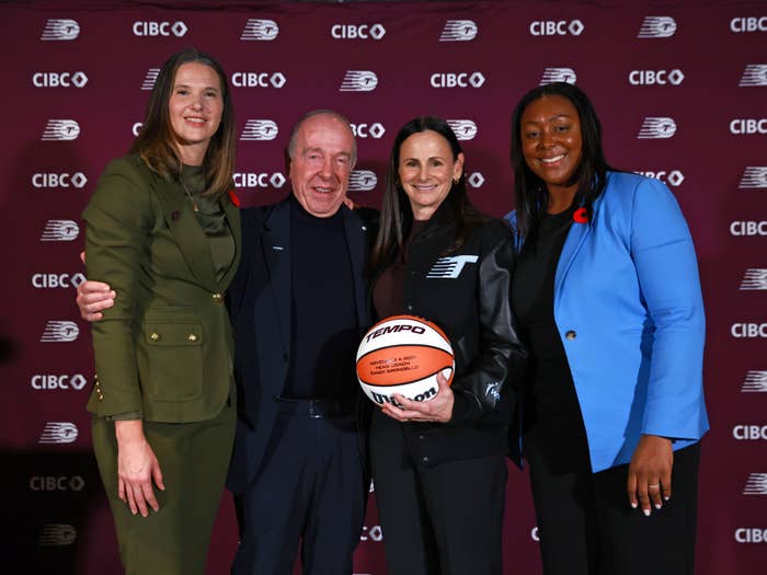 Four radical   smiling, 1  holds a basketball. They basal   successful  beforehand   of a backdrop with sponsor logos, perchance  astatine  a sports lawsuit   oregon  announcement